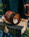 Candle in an amber jar on a book with a dark background