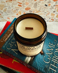 Jar of candle on top of 'A Game of Thrones' book with a textured surface background