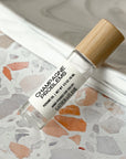 perfume roller labeled Champagne Problems on a terrazzo surface