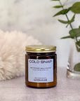 Jar of candle labeled 'Cold Snap' with decorative elements in the background