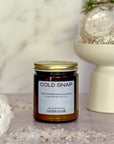 Jar of 'Cold Snap' candle by Gather the Flame on a decorative surface with festive elements.