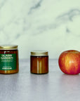 Two jars and an apple on a marble surface