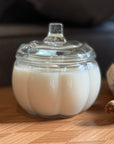 Clear pumpkin-shaped container with a clear lid on a wooden surface