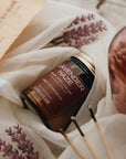 Lavender-scented product with wooden sticks on a textured fabric background