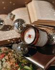 Candle with decorative elements on an open book