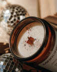 Candle with decorative label on a festive background