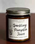 A jar candle with a label reading 'Sparkling Pumpkin Juice' on a brown surface.