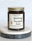 A jar candle with a label reading 'Sparkling Pumpkin Juice' on a marble-like surface.