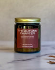 Candle labeled The Autumn Chapter on a light background