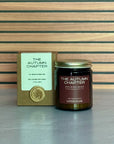 Candle labeled The Autumn Chapter with packaging on a wooden background