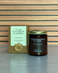 Candle labeled 'Your Favorite Flannel' with packaging on a striped background