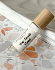 A perfume roller with clear glass bottle and a bamboo wooden cap, labeled with 'Your Favorite Flannel' on a terrazzo surface.