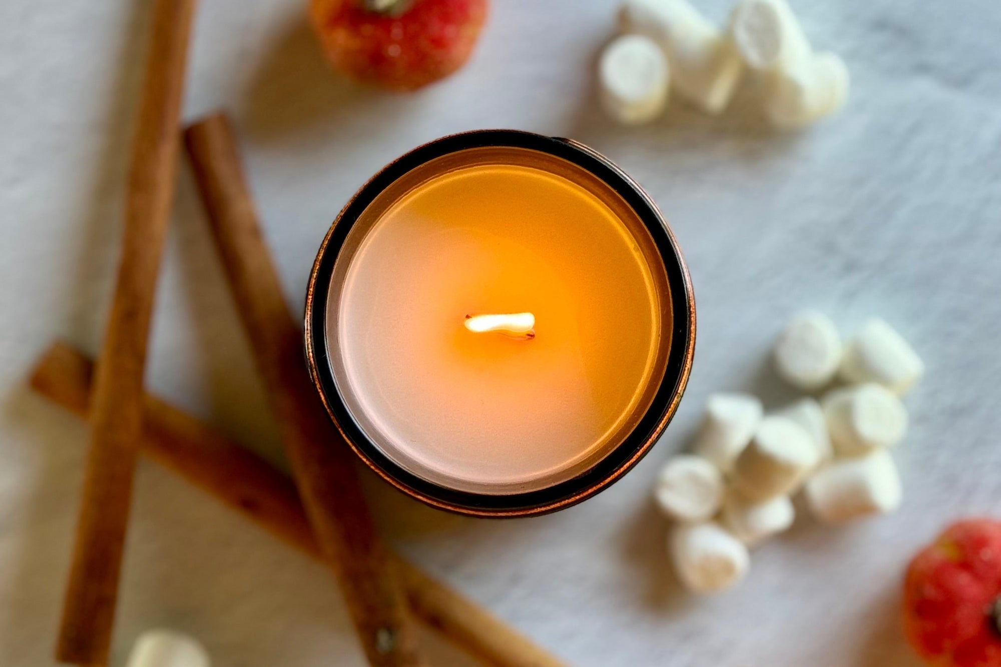 Hand-poured coconut wax candle with FSC-certified wooden wick burning softly, showing wide flame and soft ambiance.