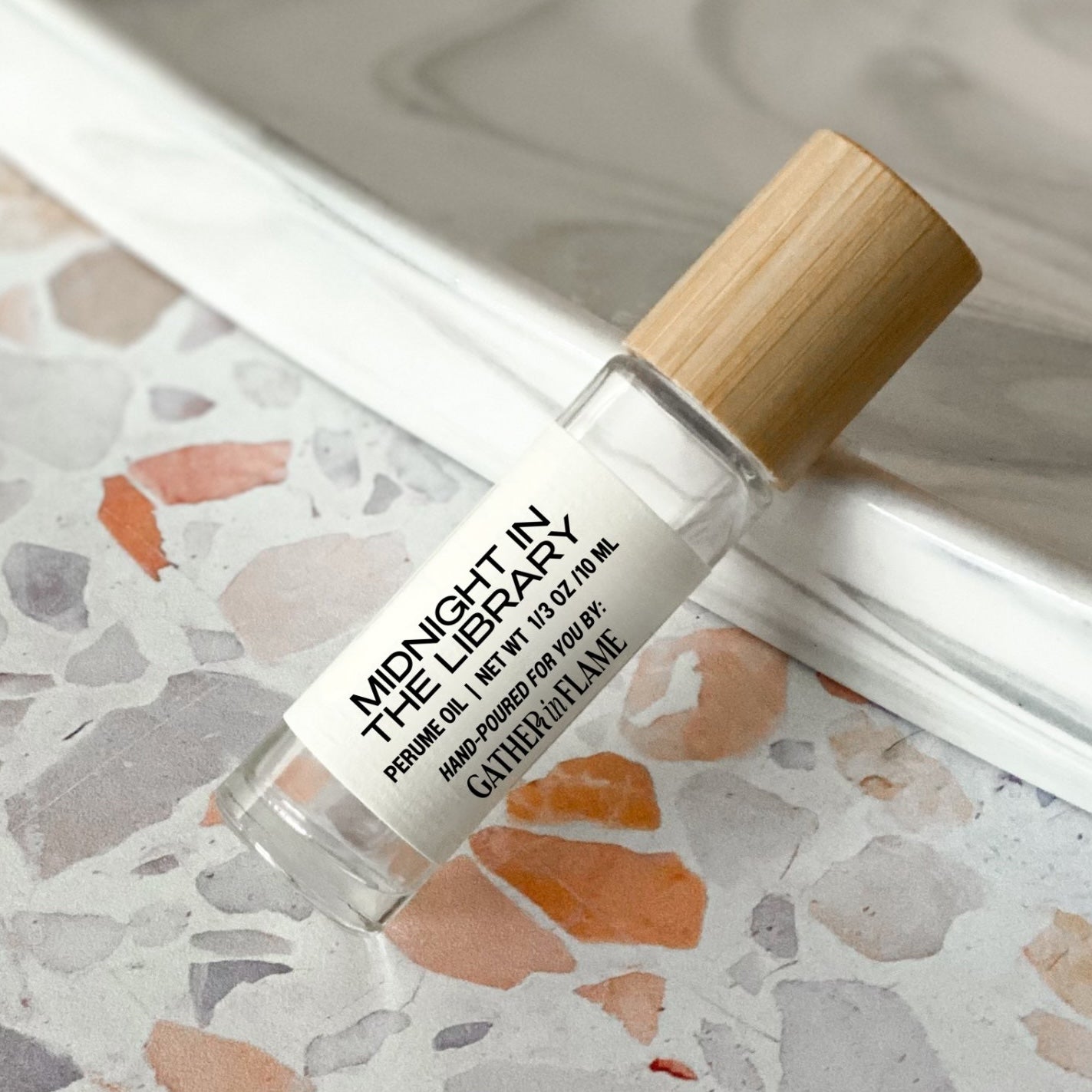 perfume roller labeled Midnight in the Library on a terrazzo surface