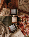 Three small jars with labels on a textured surface with floral patterns in the background
