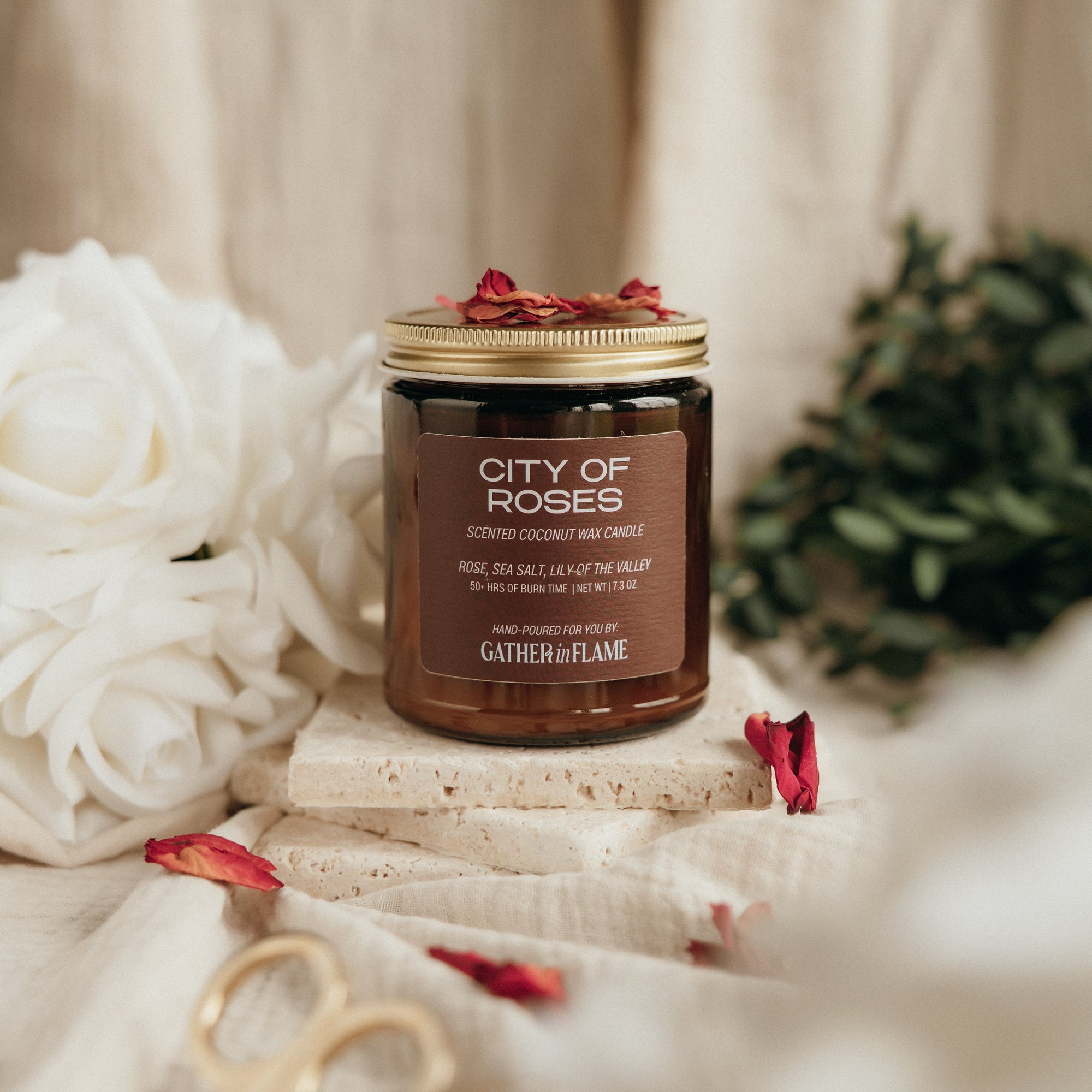 Candle labeled 'City of Roses' with decorative elements on a soft background