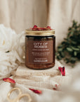Candle labeled 'City of Roses' with decorative elements on a soft background