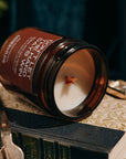 Candle in an amber jar on top of a book with a dark background