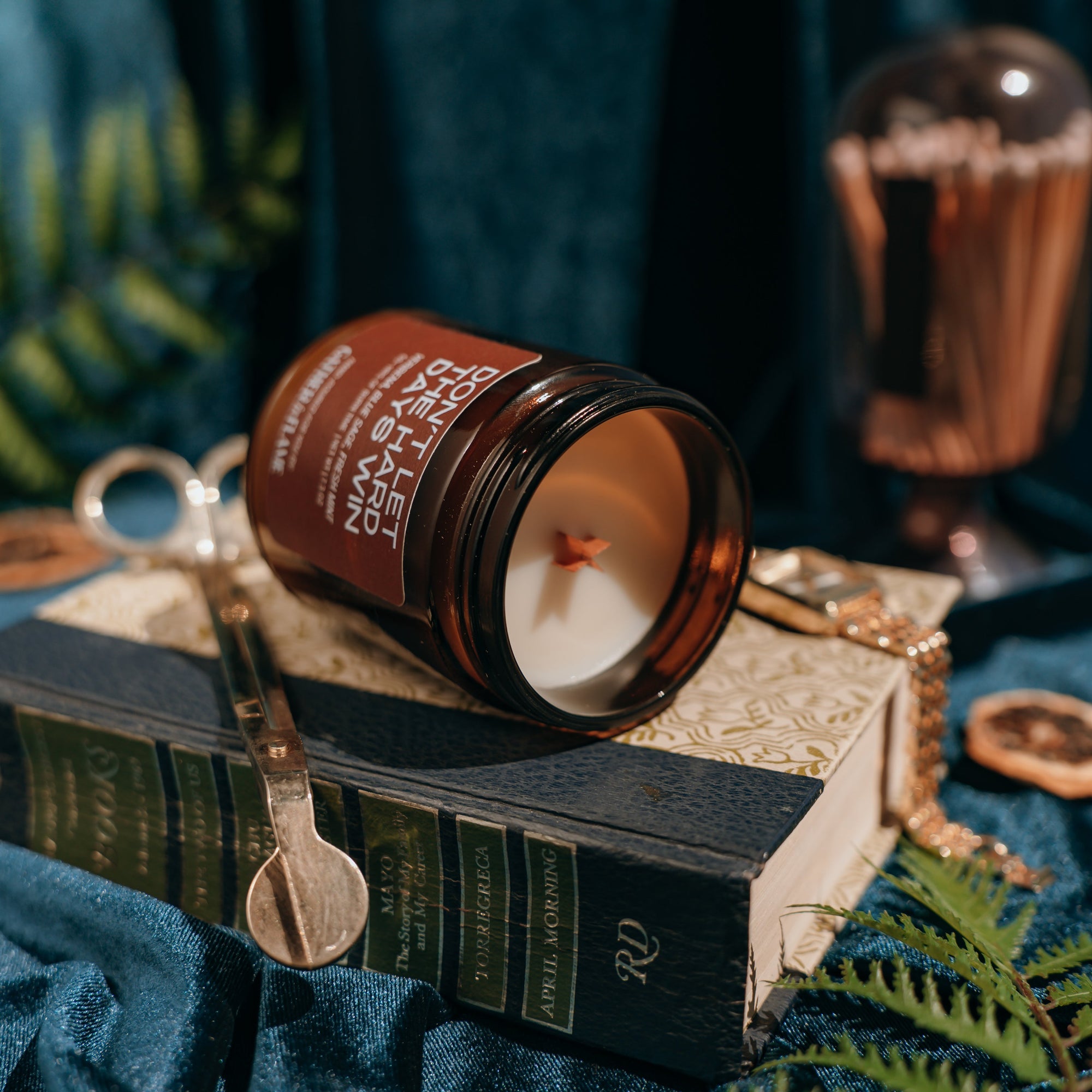 Candle in an amber jar on a book with a dark background