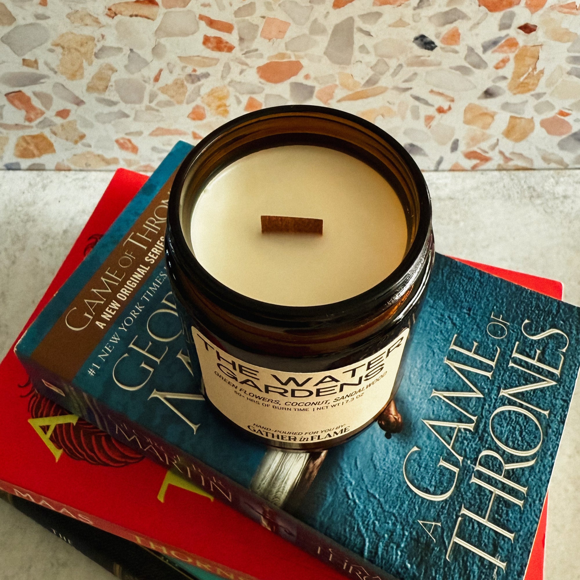 Jar of candle on top of 'A Game of Thrones' book with a textured surface background