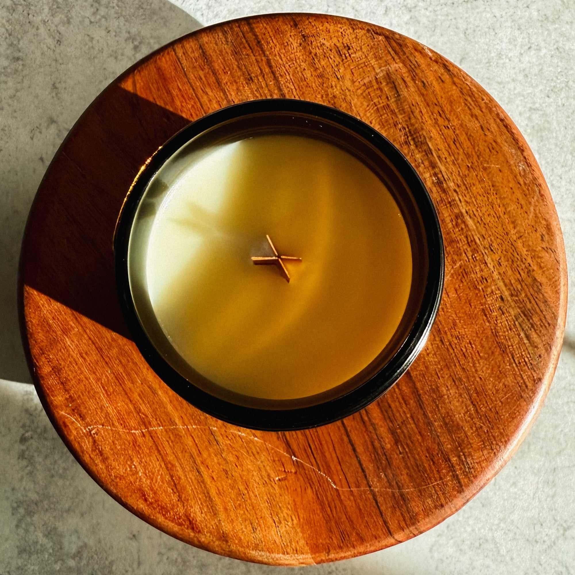 Candle in a wooden holder on a textured surface