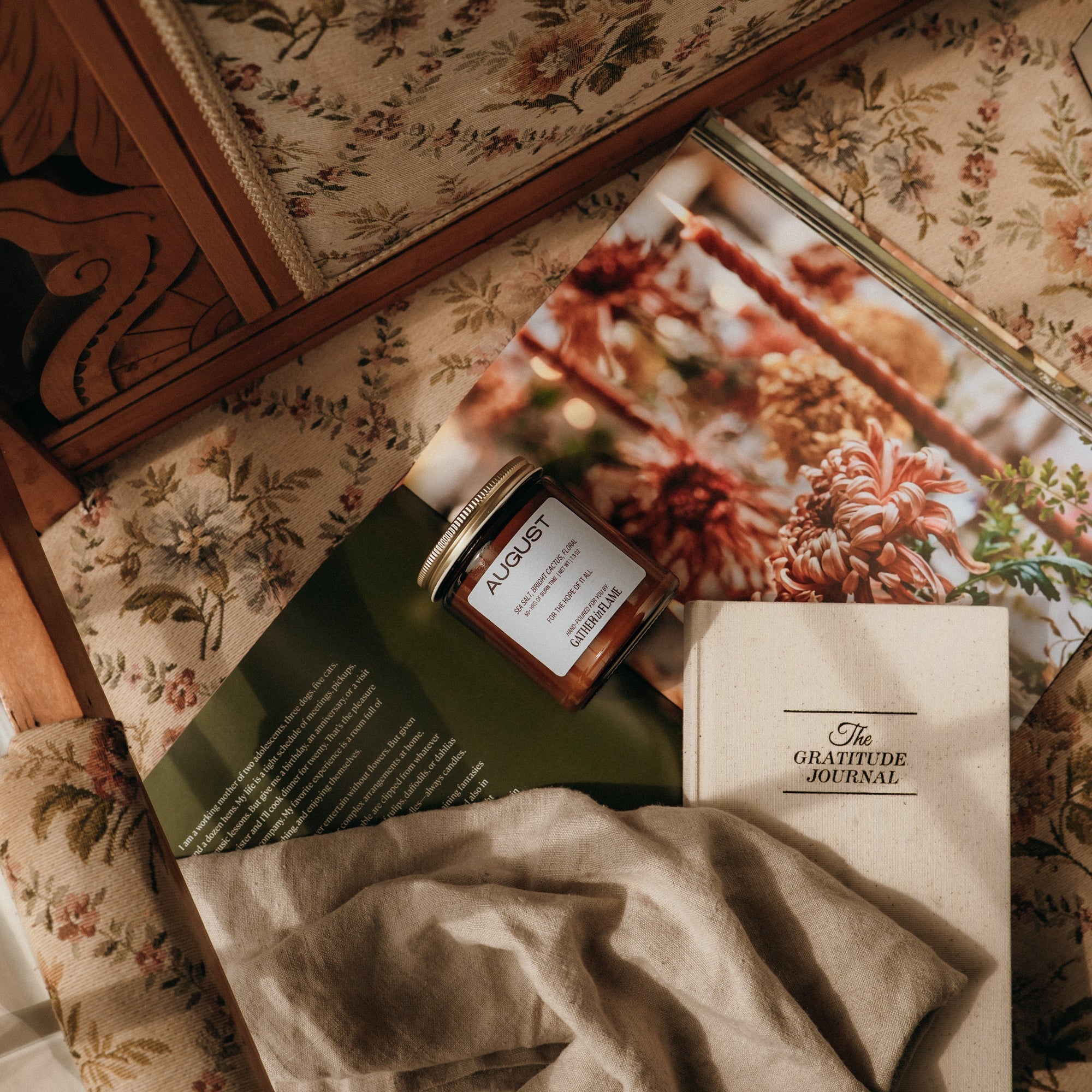 Journals and a jar on a floral-patterned surface
