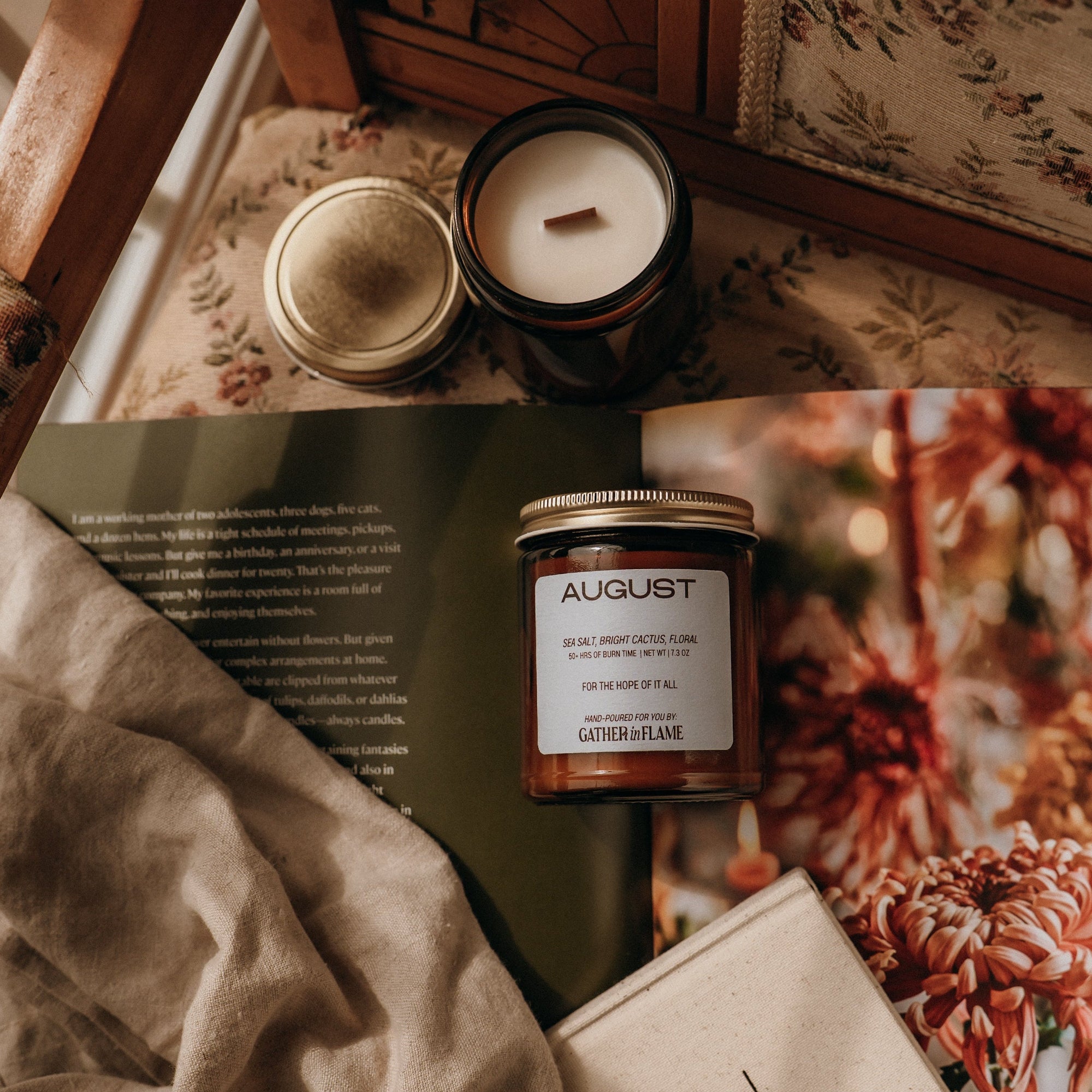 Candles and a book on a textured surface with a floral pattern