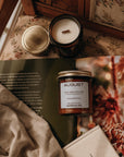 Candles and a book on a textured surface with a floral pattern