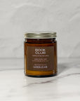 Amber glass jar candle labeled Book Club facing front with a white background.