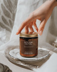 Bouge Hotel candle on a silver tray with a hand reaching towards it