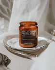Candle jar labeled 'Champagne Problems' on a decorative tray with a soft, neutral background.