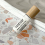 perfume roller labeled Champagne Problems on a terrazzo surface