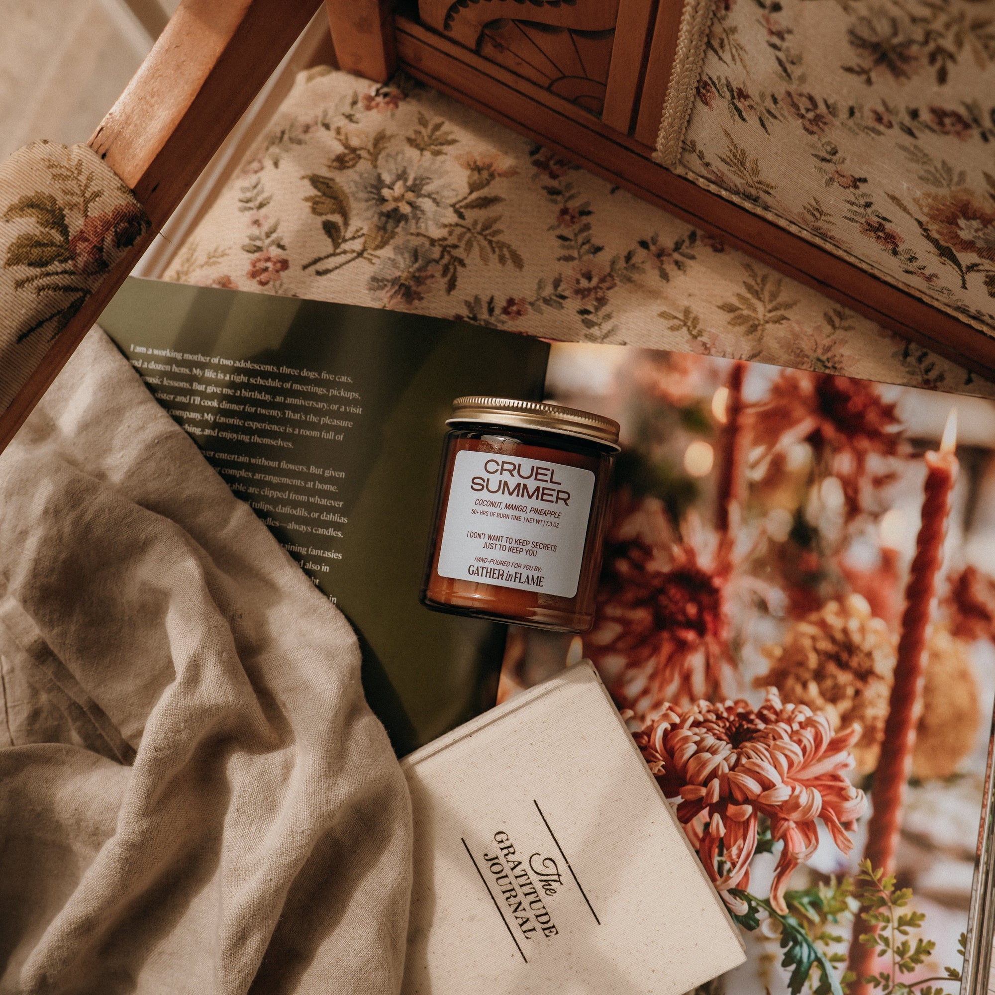 Candle and book on a floral-patterned surface