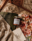 Candle and book on a floral-patterned surface