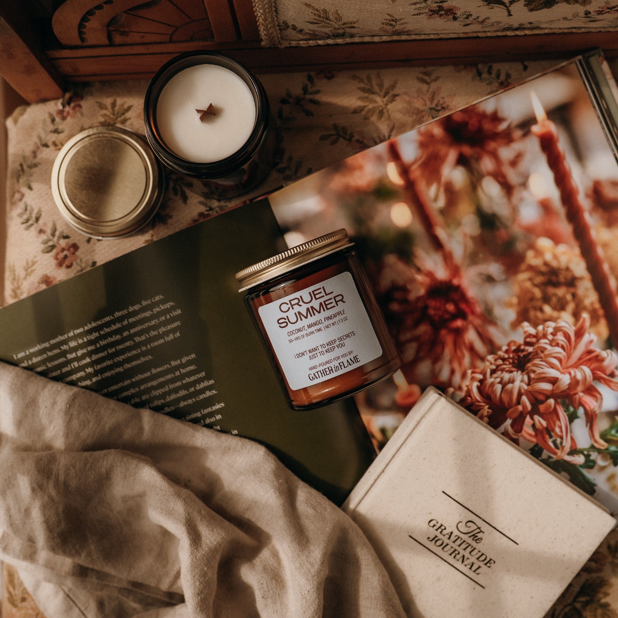 Cruel Summer product on a surface with a magazine and candle