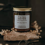Candle jar labeled 'Fated Mates' on a dark background with dried flowers and scissors.