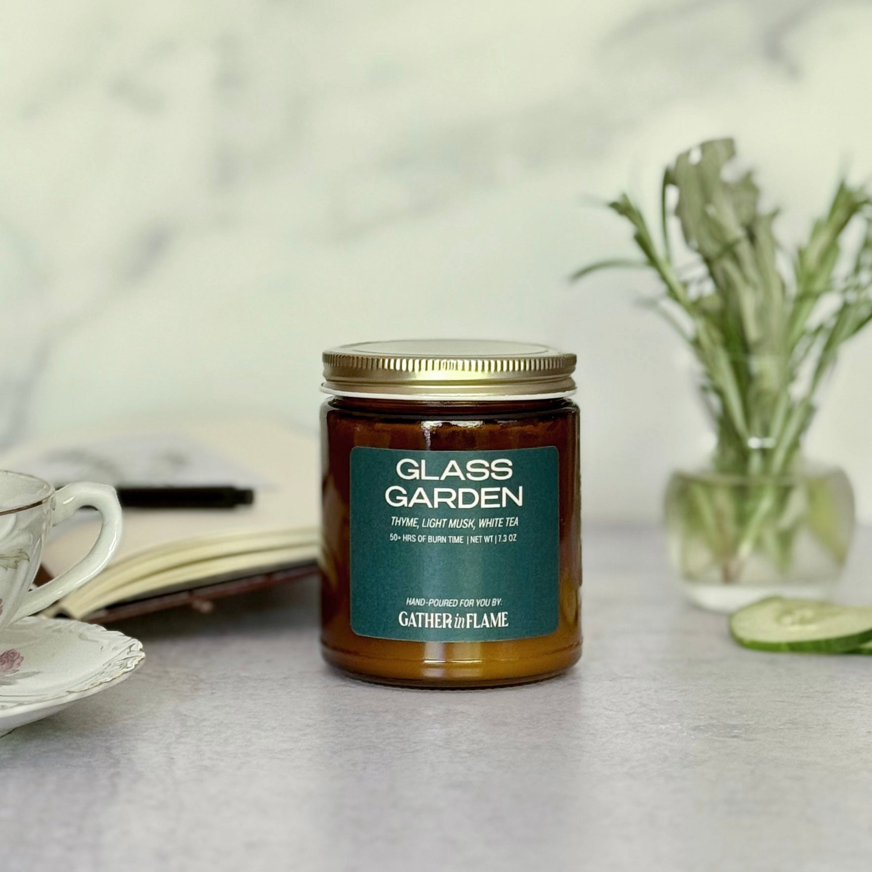Candle jar labeled 'Glass Garden' on a table with a blurred background