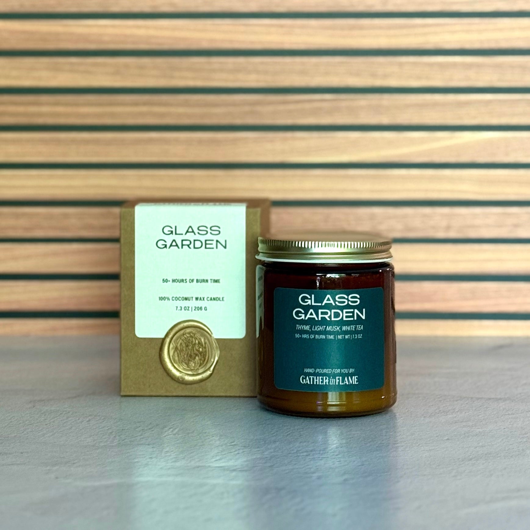 Glass Garden candle and packaging on a wooden surface