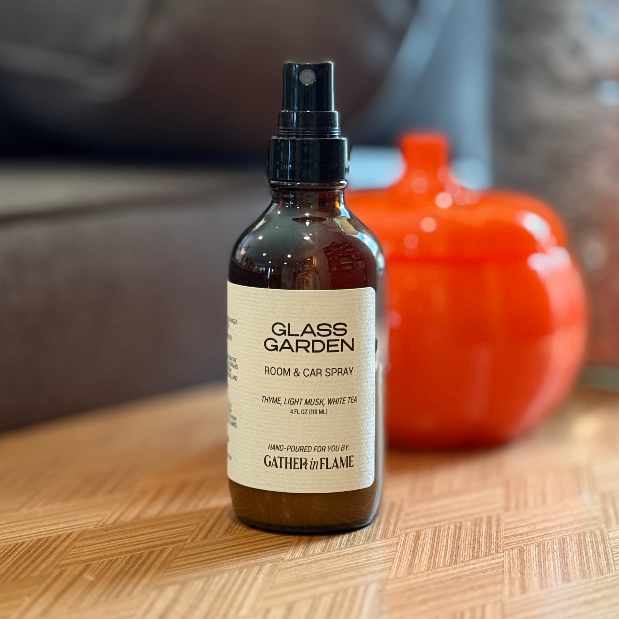 Glass Garden room and car spray bottle on a wooden surface with a blurred background