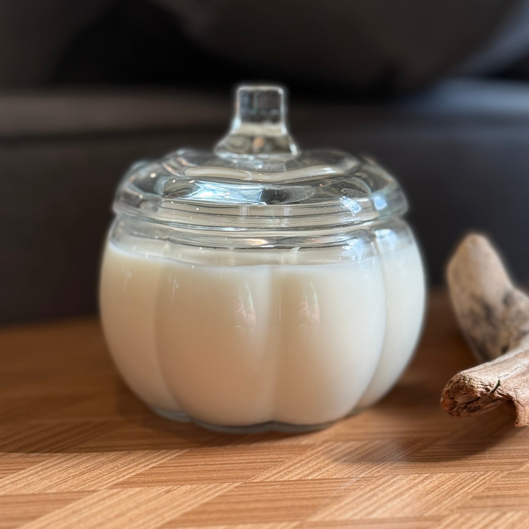 Clear pumpkin-shaped container with a clear lid on a wooden surface