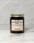 Amber glass jar candle labeled In My Romantasy Era facing forward with a white background.