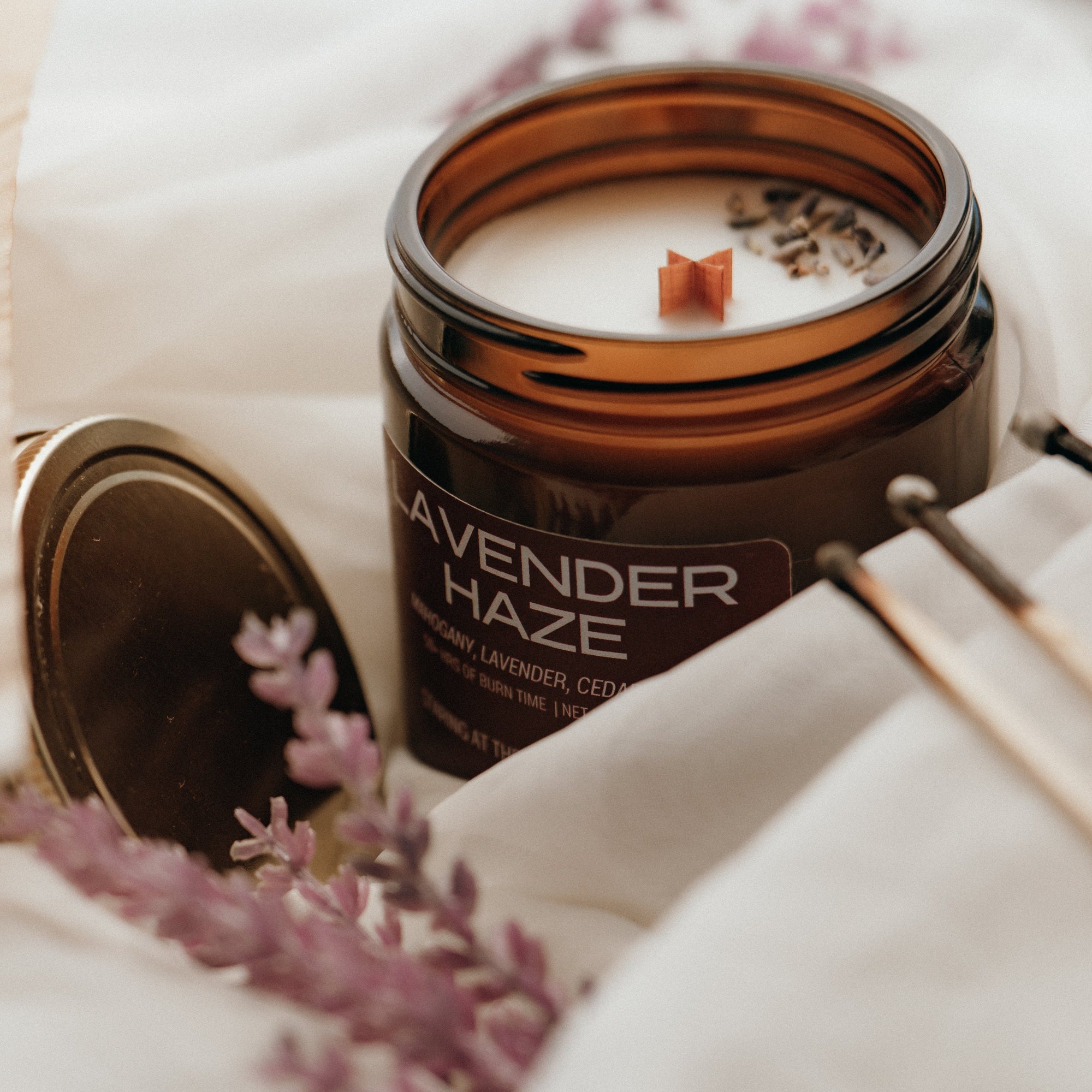 Candle labeled 'Lavender Haze' with lavender flowers around it