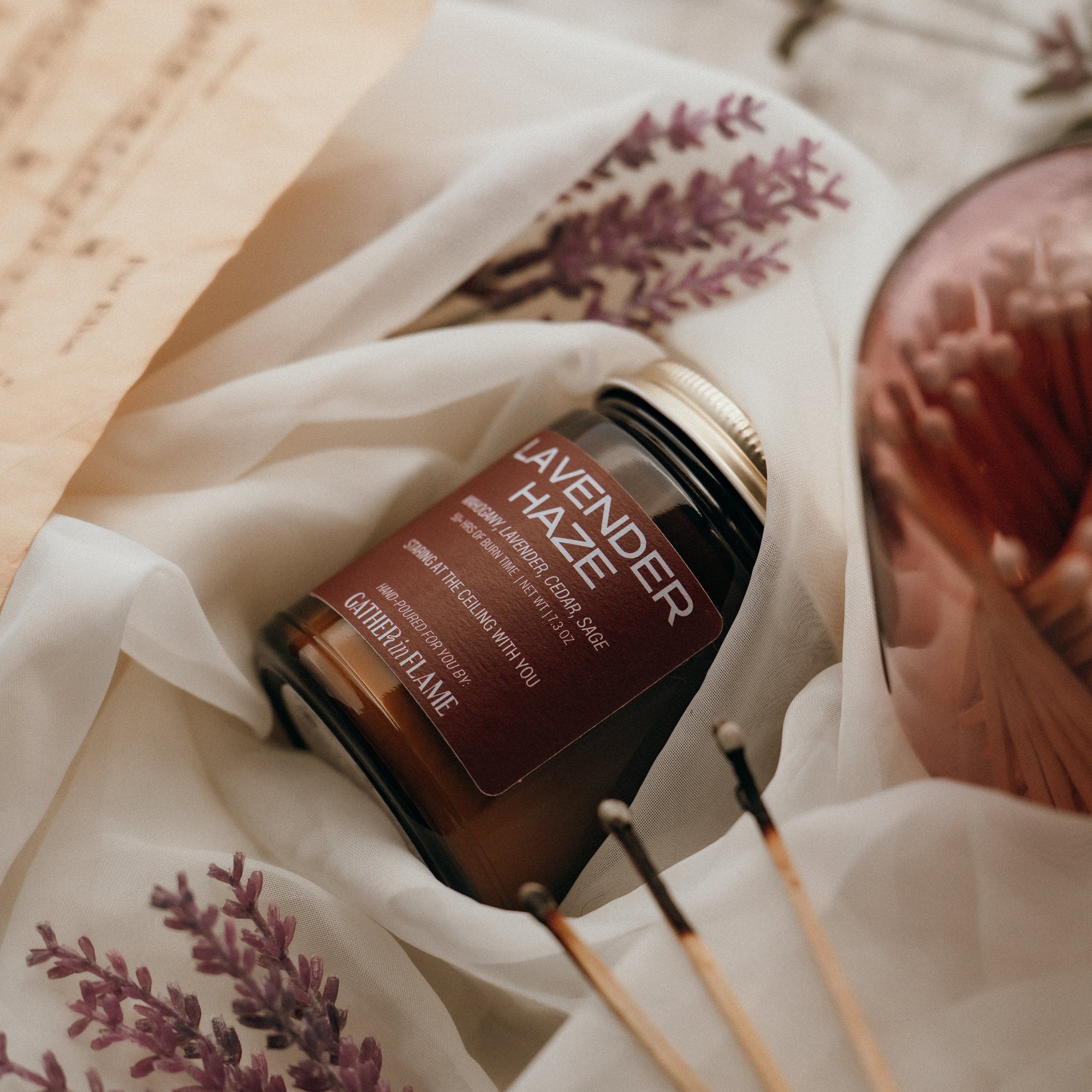 Lavender-scented product with wooden sticks on a textured fabric background