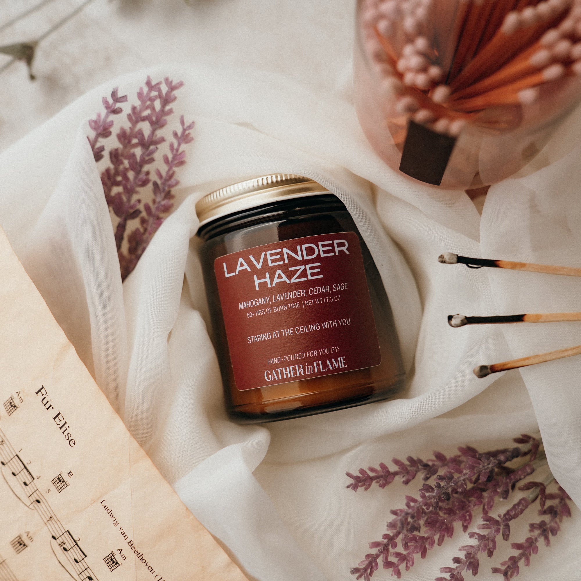 Jar of 'Lavender Haze' candle with decorative elements on a soft surface