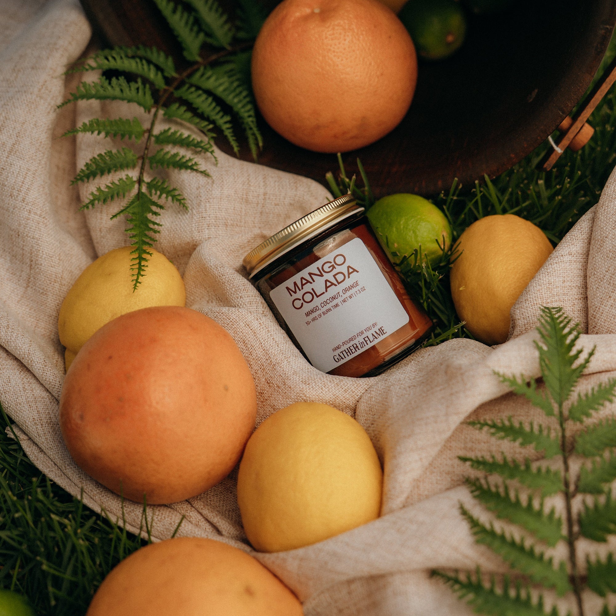 Jar of mango colada on a cloth with fruits and leaves