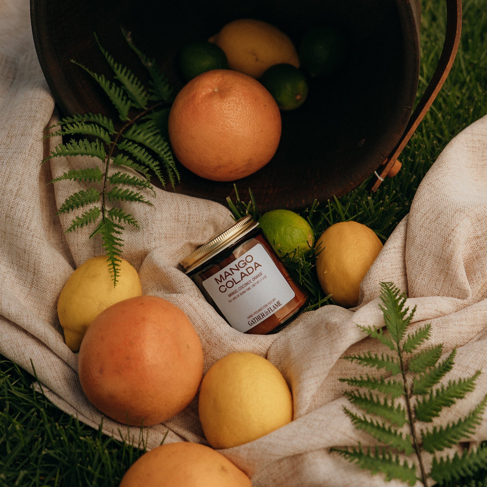 Jar of Manuka Honey surrounded by fruits on a natural fabric with greenery
