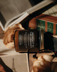 Book with a  'Midnight in the Library' candle on top, surrounded by roses and a photo of the Eiffel Tower.