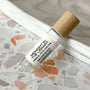 perfume roller labeled Midnight in the Library on a terrazzo surface