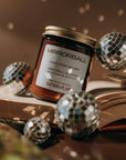 Jar of 'Mirrorball' candle with disco balls on an open book
