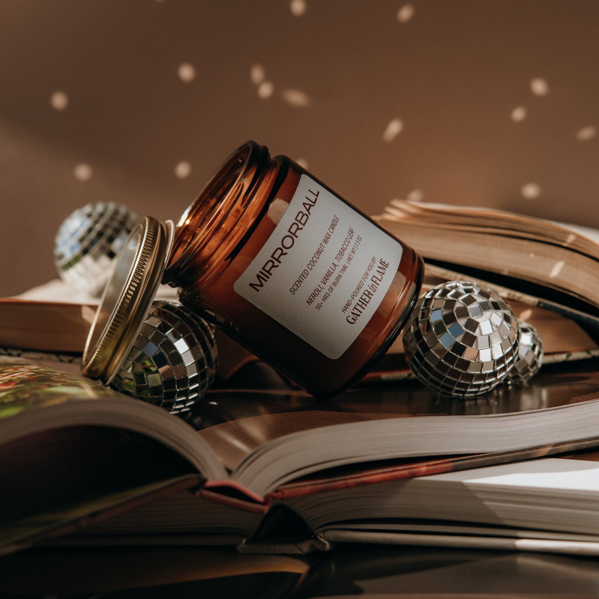 Jar of Mirrorball on an open book with decorative items
